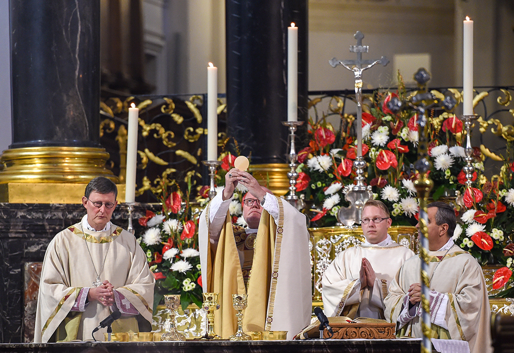 Os cardeais alemÃ£es Rainer Maria Woelki, de ColÃ´nia, e Reinhard Marx, de Munique, elevam a Eucaristia durante missa na catedral de Fulda, em 23 de setembro de 2014.