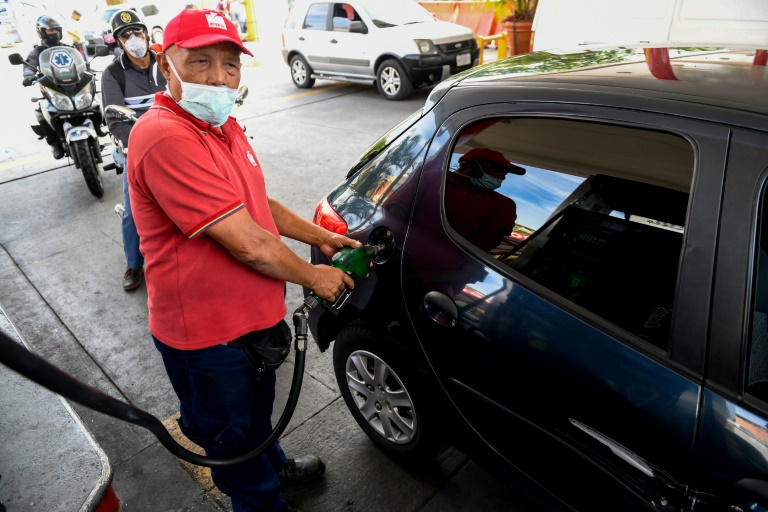 Funcionário de posto de gasolina abastece carro em Caracas
