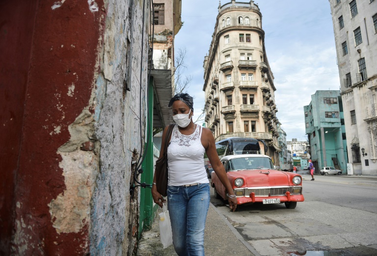 Mulher caminha de máscara pelas ruas de Havana
