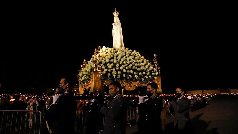 Fiéis carregam a imagem de Nossa Senhora de Fátima, durante o 104º aniversário das aparições da Virgem Maria aos pastorinhos, em seu santuário em Portugal
