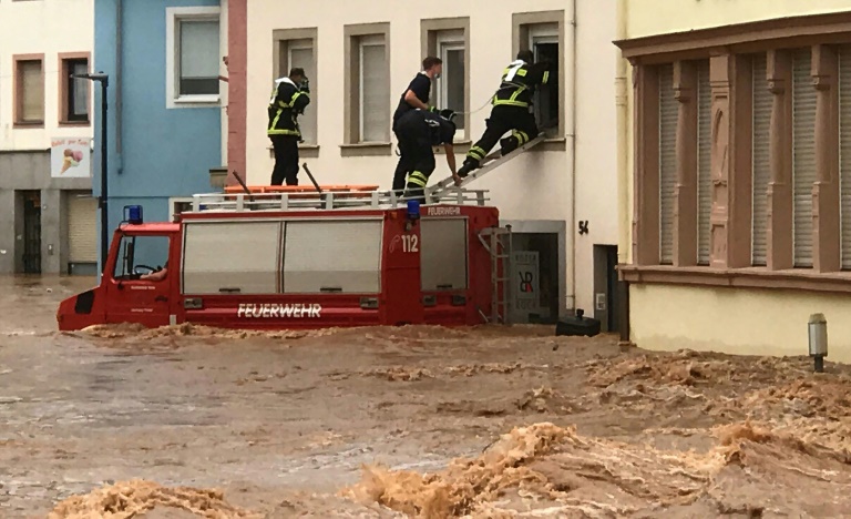 Bombeiros entram em uma casa pela janela em uma rua inundada em Trier, em 15 de julho de 2021, no oeste da Alemanha, onde fortes chuvas causaram inundações