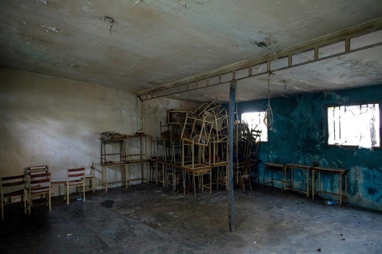 Carteiras do que foi uma escola em Ologá, um isolado povoado de pescadores na Venezuela, amontoadas há quatro anos em uma sala escura e empoeirada