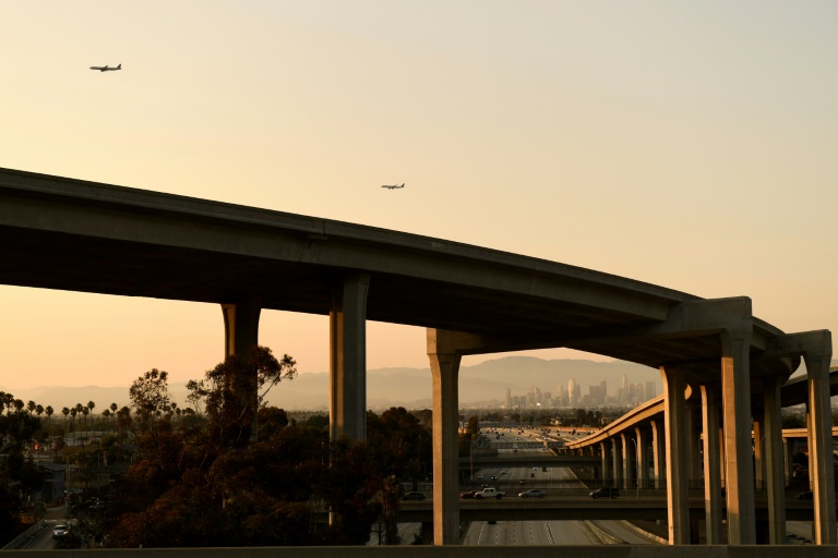 Dois aviões se aproximam do aeroporto internacional de Los Angeles para aterrissar, enquanto veículos circulam pela rodovia 110, em 16 de julho de 2021