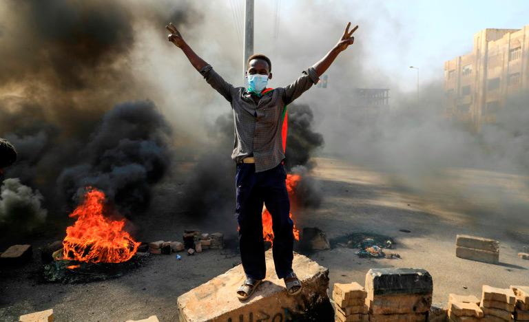 Manifestantes sudaneses queimam pneus em avenida da capital Cartum para denunciar as detenções de autoridades civis pelas Forças Armadas