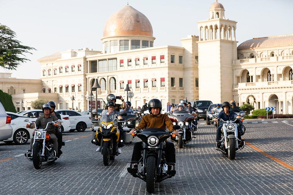 O presidente brasileiro Jair Bolsonaro (C) faz passeio de Harley-Davidson pelas ruas de Doha, no Catar, em 17 de novembro