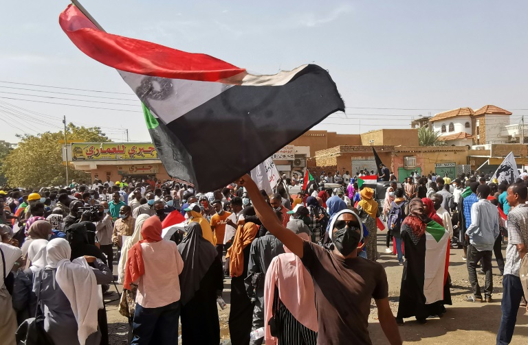 Manifestante balança bandeira nacional em protesto em Cartum