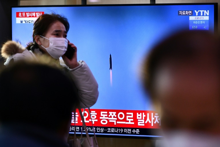 Ao fundo, uma tela exibe, em 14 de janeiro de 2022, em uma estação ferroviária de Seul, noticiário com imagens de arquivo sobre o teste de míssil de Pyongyang