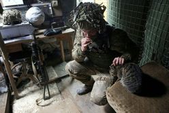 Soldado ucraniano acaricia um gato em 9 de janeiro de 2022 em Avdivka, na linha de frente com os separatistas (Anatolii STEPANOV/AFP)
