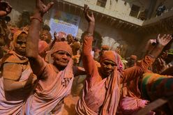Viúvas cobertas de tinta colorida dançam em um templo para as celebrações do Holi, em Vrindavan, Índia (Money SHARMA/AFP)