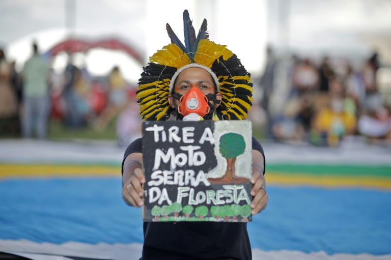 Um indígena protesta contra o desmatamento e políticas ambientais de Jair Bolsonaro em Brasília em 9 de março de 2022