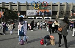 Seguidores del grupo de K-pop BTS toman fotografías a su llegada al concierto en el estadio olímpico de Jamsil en Seúl, el 10 de marzo de 2022 (Jung Yeon-je/AFP)