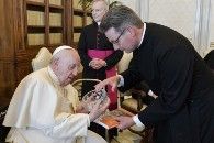 O Reverendo Will Adam, vice-secretário-geral da Comunhão Anglicana, oferece um presente ao Papa Francisco durante uma reunião em 13 de maio de 2022. ((Foto CNS/Vatican Media))