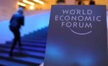 Funcionário limpa a logo do Fórum Econômico Mundial (WEF) em Davos (Suíça) (Fabrice COFFRINI/AFP)