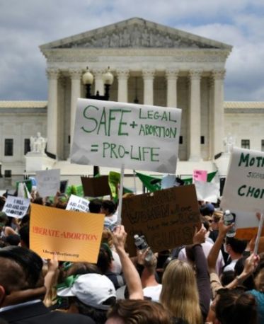 Ativistas do direito ao aborto erguem seus cartazes do lado de fora da Suprema Corte dos EUA em Washington, DC (OLIVIER DOULIERY/AFP)