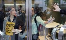Ativistas climáticos colam as mãos com cola na entrada do FMI (Thomas COEX/AFP)