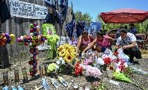 Pessoas deixam flores em memorial às vítimas encontradas mortas em caminhão abandonado no Texas (CHANDAN KHANNA/AFP)